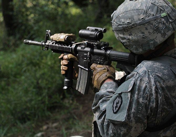 Боец 5-го эскадрона 1-го кавалерийского полка 25-й пехотной девизии Армии США тактически целится из тактического M-4 на учениях.