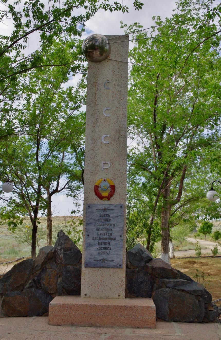 Памятник «Спутник» на территории Байконура. На табличке высечено: «Здесь гением советского человека начался дерзновенный штурм космоса — 1957»